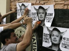 Demonstranti před budovou filipínského Kongresu útočí rajčaty na plakáty s ne příliš lichotivým vyobrazením prezidentky Arroyové