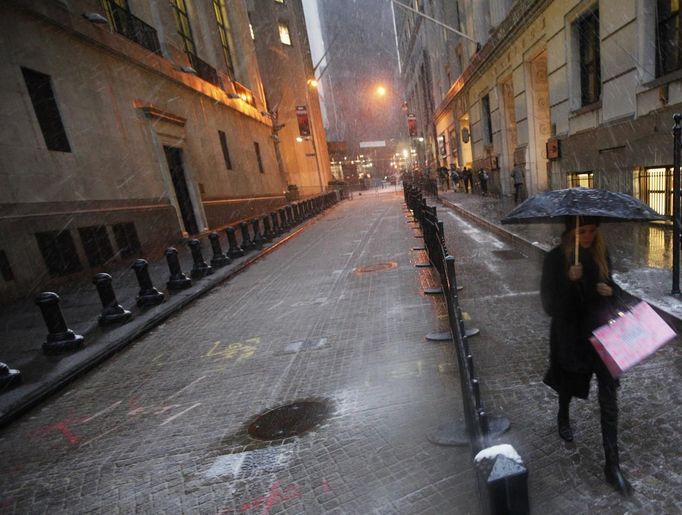 A woman walks by the New York Stock Exchange through the wind and snow in New York's financial district, November 7, 2012. A wintry storm dropped snow on the Northeast and threatened to bring dangerous winds and flooding to a region still climbing out from the devastation of superstorm Sandy. REUTERS/Brendan McDermid (UNITED STATES - Tags: DISASTER ENVIRONMENT) Published: Lis. 7, 2012, 11:57 odp.