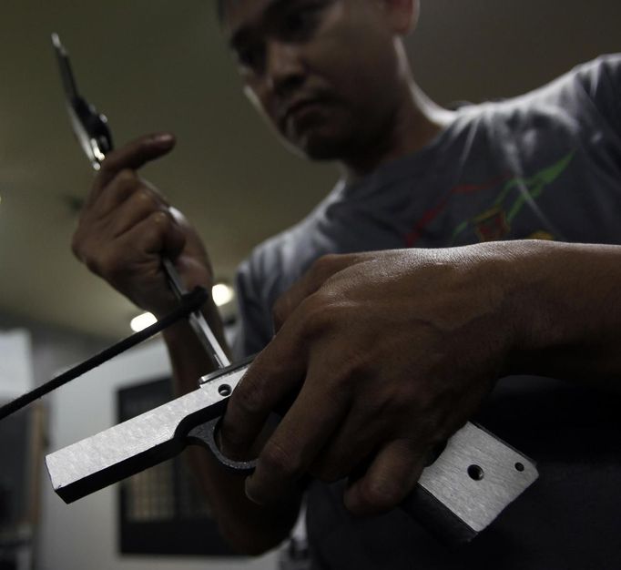 A former illegal gunsmith assembles a pistol at Shooters Arms, a gun manufacturing company exporting different kinds of weapons to other countries, in Cebu city in central Philippines July 6, 2012. In the Philippines, they vote with their trigger fingers. Elections mean big business for illegal gunsmiths, who are looking forward to 2013 mid-term polls. With election-related violence commonplace, the Philippines imposes a ban on the carrying of guns for six months, from campaigning to the proclamation of winners. Picture taken July 6, 2012. To match Feature PHILIPPINES-GUNS/ REUTERS/Erik De Castro (PHILIPPINES - Tags: SOCIETY POLITICS BUSINESS CRIME LAW) Published: Čec. 29, 2012, 1:40 dop.