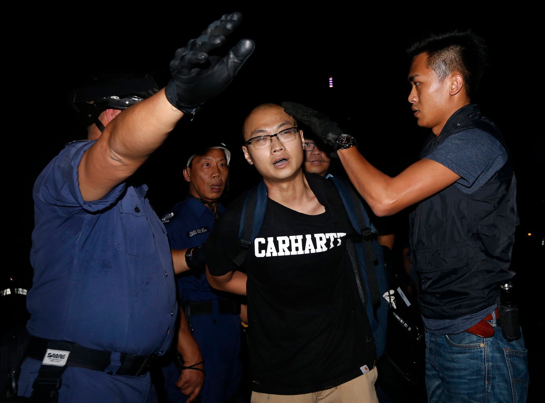 Riot policemen detain a pro-democracy protester during a confrontation outside government headquarters in Hong Kong