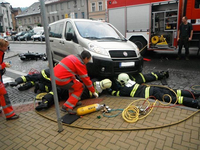 Hasiči zachraňovali motorkáře zaklíněného pod dodávkou.