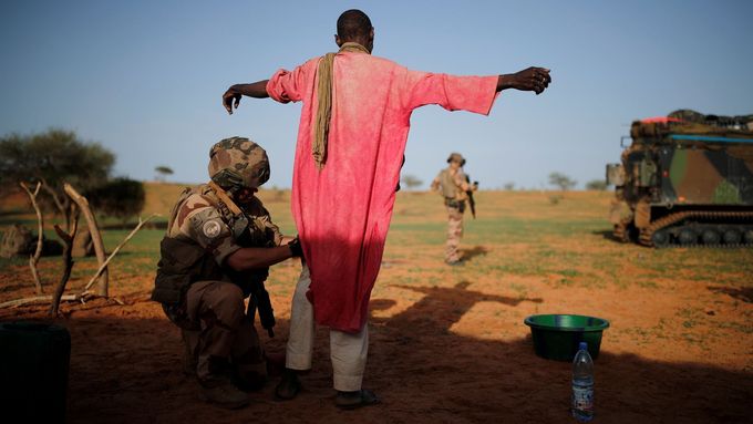Francouzský voják v Mali prohledává neznámého muže.