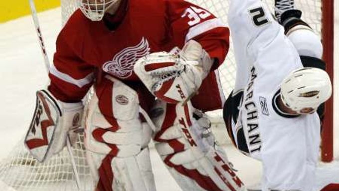 Hokejita Anaheimu Todd Marchant padá do branky detroitského Dominika Haška v nedělním semifinále play off NHL.
