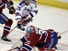 Petr Průcha z New Yorku Rangers (v bílém) se snaží dorazit kotouč za záda montrealského gólmana Davida Aebischera.