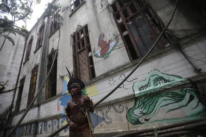 A native Indian stands at the Brazilian Indian Museum in Rio de Janeiro, March 20, 2013. A native Indian community of around 30 individuals who have been living in the abandoned Indian Museum since 2006, were summoned to leave the museum in 72 hours by court officials since last Friday, local media reported. The group is fighting against the destruction of the museum, which is next to the Maracana Stadium. REUTERS/Ricardo Moraes (BRAZIL - Tags: POLITICS CIVIL UNREST) Published: Bře. 20, 2013, 10:45 odp.