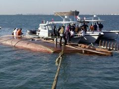 Záchranáři vlečou vrak lodi, která se potopila u bahrajnského pobřeží.