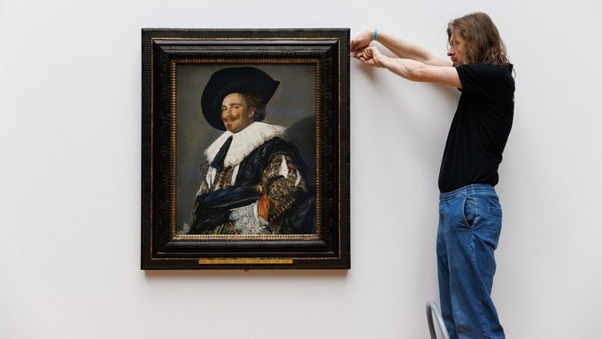 Pracovník nizozemského Rijksmusea připevňuje obraz Smějící se kavalír od Franse Halse z roku 1624.