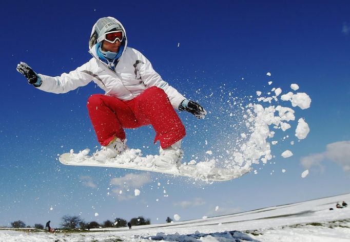 Teacher Kirsty Willett snowboards in the snow on the South Downs near Brighton in southern England March 12, 2013. Transport was disrupted on Tuesday following a second day of heavy snowfall in southern England. REUTERS/Luke MacGregor (BRITAIN - Tags: ENVIRONMENT SOCIETY SPORT) Published: Bře. 12, 2013, 5:56 odp.