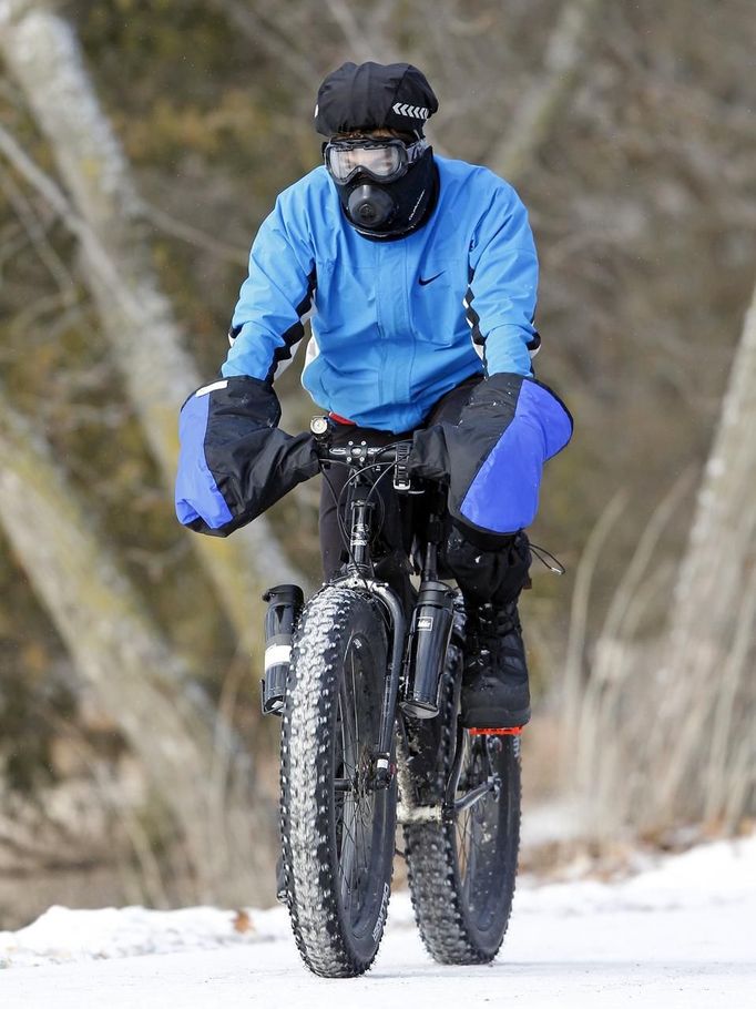 Steve Tannen wears heavy clothing to protect himself against freezing wind chills as he practices for an upcoming bike race in northern Minnesota near Lake Harriet in Minneapolis, January 23, 2013. The Upper Midwest remains locked in a deep freeze, with bitter sub-zero temperatures and wind chills stretching into a fourth day across several states due to waves of frigid Arctic air. REUTERS/Eric Miller (UNITED STATES - Tags: ENVIRONMENT) Published: Led. 23, 2013, 8:08 odp.