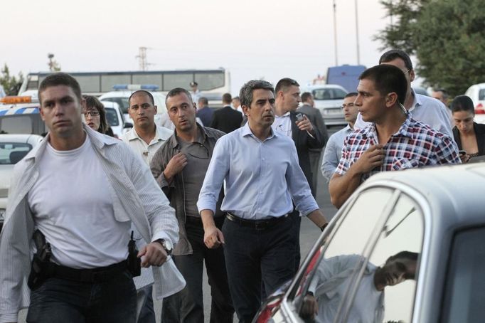 Bulgaria's President Rosen Plevneliev (C) walks near the site of an explosion at Bulgaria's Burgas airport July 18, 2012. At least four people were killed and over 20 injured by an explosion on a bus carrying Israeli tourists outside the airport of the Black Sea city of Burgas on Wednesday. The mayor of the city, on Bulgaria's Black Sea coast, said the bus was carrying Israeli tourists, but the police could not immediately confirm the nationality of the tourists. Police said several other buses at the site had been damaged. REUTERS/Nikolay Doncev (BULGARIA - Tags: DISASTER TRANSPORT POLITICS)