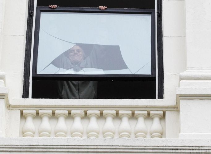 A man takes down a broken window above the site of the first explosion on Boylston Street after the street reopened to the public for the first time since the Boston Marathon bombings in Boston, Massachusetts April 24, 2013. REUTERS/Jessica Rinaldi (UNITED STATES - Tags: CRIME LAW CIVIL UNREST SOCIETY) Published: Dub. 24, 2013, 3:35 odp.