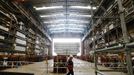 A worker passes the forward section of the aircraft carrier HMS Queen Elizabeth as it is moved onto a barge at HM Naval Base in Portsmouth, southern England May 14, 2012. The hull will be transported by a sea going barge to Rosyth in Scotland where the ship will be assembled in dry dock. REUTERS/Luke MacGregor (BRITAIN - Tags: BUSINESS EMPLOYMENT MILITARY) Published: Kvě. 14, 2012, 2:57 odp.