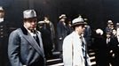 Al Capone se dívá na fotografy při odchodu od federálního soudu v Chicagu se svým právníkem Michaelem Ahernem 11. října 1931. Kolorovaná fotografie