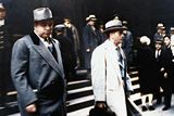 Al Capone se dívá na fotografy při odchodu od federálního soudu v Chicagu se svým právníkem Michaelem Ahernem 11. října 1931.