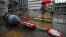 A pedestrian walks past a fallen bus-stop signpost in Hong Kong July 24, 2012. Typhoon Vicente hit Hong Kong on Tuesday, disrupting business across the financial hub, with offices and the stock market to remain closed for at least part of the morning after the city raised its highest typhoon warning overnight. REUTERS/Bobby Yip (CHINA - Tags: ENVIRONMENT DISASTER TPX IMAGES OF THE DAY) Published: Čec. 24, 2012, 1:33 dop.