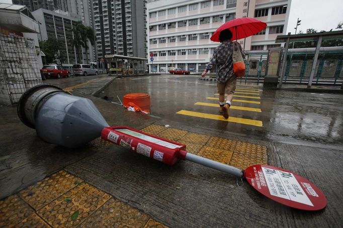 A pedestrian walks past a fallen bus-stop signpost in Hong Kong July 24, 2012. Typhoon Vicente hit Hong Kong on Tuesday, disrupting business across the financial hub, with offices and the stock market to remain closed for at least part of the morning after the city raised its highest typhoon warning overnight. REUTERS/Bobby Yip (CHINA - Tags: ENVIRONMENT DISASTER TPX IMAGES OF THE DAY) Published: Čec. 24, 2012, 1:33 dop.