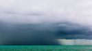 Inclement Weather at Sea Original caption:Storm clouds, heavy rain, and a waterspout are indicate rough weather to come.