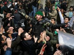 Demonstranti v centru Teheránu dávají na hlavu policisty zelený šátek. Zelená byla symbolem opozičního prezidentského kandidáta Musávího. Podle zpráv z místa někteří členové bezpečnostních složek neuposlechli rozkazy velitelů a odmítli střílet do protestujících.