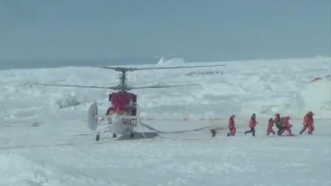 Pro pasažéry lodi Akademik Šokalskij, která uvízla v ledové pasti v Antarktidě, přiletěl čínský vrtulník (záběr z videa).