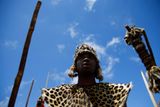 Válečník patřící k národu Zuluů tančí na počest Mandely na kopci nad hřbitovem.