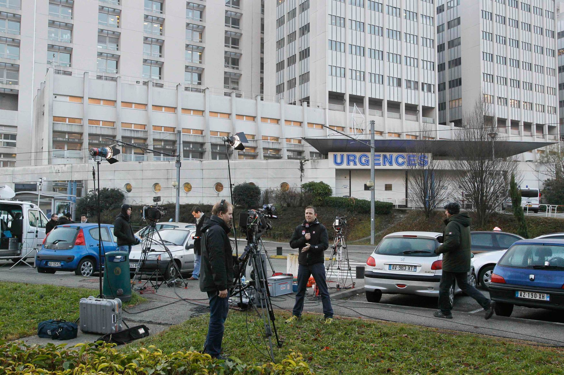 Journalists work in front of the entrance of the emergency services at the CHU Nord hospital in Grenoble, French Alps, where retired seven-times Formula One world champion Michael Schumacher is hospit