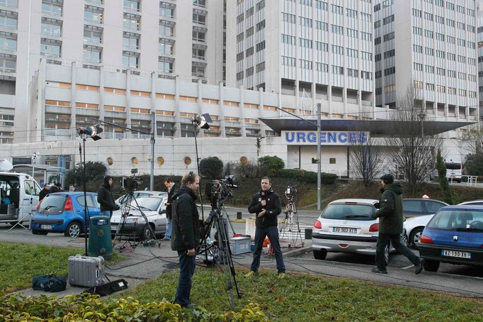 Journalists work in front of the entrance of the emergency services at the CHU Nord hospital in Grenoble, French Alps, where retired seven-times Formula One world champio