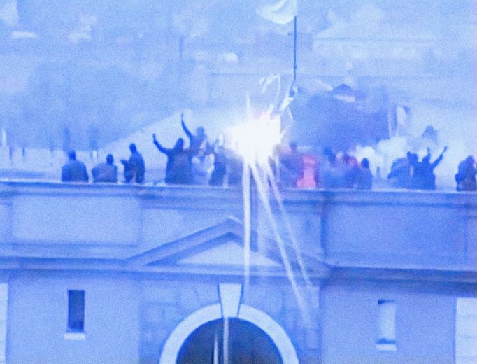 Fotoreprodukce z dobového VHS videozáznamu policejních složek ČSSR, který zachytil potlačení vzpoury vězňů ve věznici Leopoldov v březnu roku 1990.