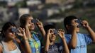 Members of a family use solar viewers to watch Venus passing between the Sun and the Earth in Cuernavaca June 5, 2012. Venus made a slow transit across the face of the sun on Tuesday, the last such passing that will be visible from Earth for 105 years. REUTERS/Margarito Perez Retana (MEXICO - Tags: ENVIRONMENT SCIENCE TECHNOLOGY) Published: Čer. 6, 2012, 3:55 dop.