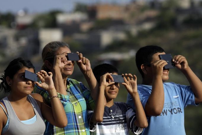 Members of a family use solar viewers to watch Venus passing between the Sun and the Earth in Cuernavaca June 5, 2012. Venus made a slow transit across the face of the sun on Tuesday, the last such passing that will be visible from Earth for 105 years. REUTERS/Margarito Perez Retana (MEXICO - Tags: ENVIRONMENT SCIENCE TECHNOLOGY) Published: Čer. 6, 2012, 3:55 dop.