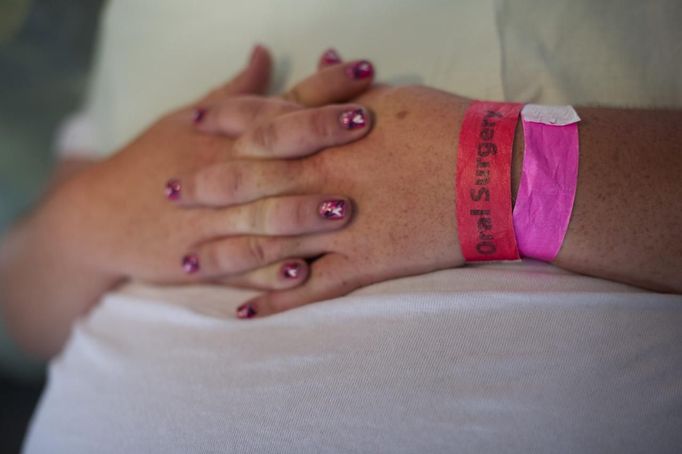 A patient with wristbands indicating her treatment waits to be called at the Remote Area Medical (RAM) clinic in Wise, Virginia July 20, 2012. RAM clinics bring free medical, dental and vision care to uninsured and under-insured people across the country and abroad. The Wise clinic was the 647th RAM expedition since 1985 and drew 1700 patients from 14 states, organizers said. Picture taken July 20, 2012. REUTERS/Mark Makela (UNITED STATES - Tags: HEALTH SOCIETY) Published: Čec. 24, 2012, 3:04 odp.