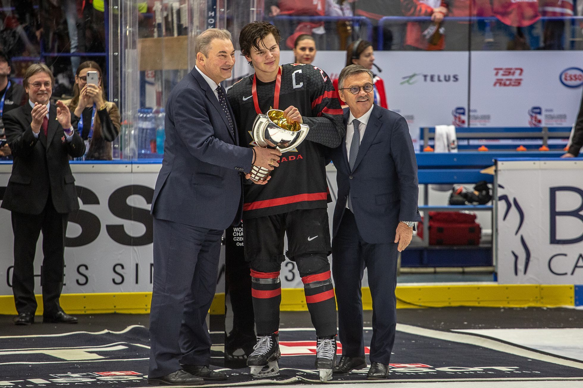 Hokejové MS juniorů 2020 v Ostravě, finále Kanada - Rusko: Vladislav Treťjak (vlevo) a René Fasel (vpravo) předávají pohár Barrettu Haytonovi
