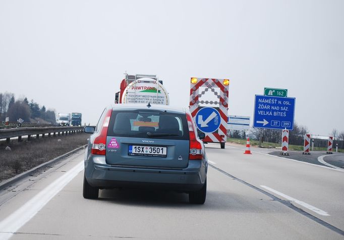 Řidiči jedoucí ve směru od Brna se s prvním omezením setkali u Velké Bíteše. Stavební firma tu stále ještě nedokončila práce na rozšiřování krajnice.