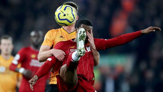 Georginio Wijnaldum z Liverpoolu odehrává míč s rukou protihráče Leandera Dendonckera z Wolverhamptonu v obličeji