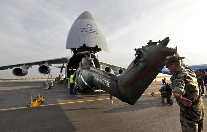 A French soldier checks the unloading of a French Puma helicopter from a Russian Antonov 224 at the Mali air force base near Bamako January 19, 2013. Islamist rebels in Mali abandoned the central town of Diabaly on Friday after fleeing a French air strike, military sources said, while West African troops arrived in Bamako to take on the insurgents in Mali's north. Reuters journalists travelling north of Bamako saw residents welcoming French troops and, in places, French and Malian flags hung side by side. REUTERS/Eric Gaillard (MALI - Tags: CIVIL UNREST CONFLICT MILITARY) Published: Led. 19, 2013, 7:10 odp.