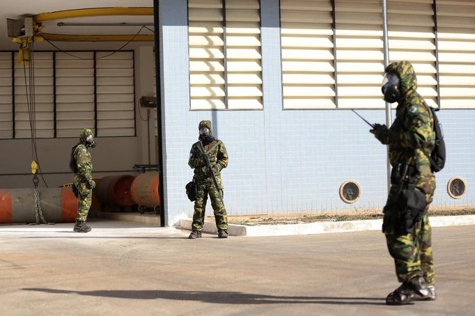 Brazilian army soldiers wearing chemical suits participate in an anti-terror simulation exercise as part of the preparation for the upcoming 2013 FIFA Confederations Cup in Brasilia. May 22, 2013. About 100 soldiers took part in the exercise which include preventive strikes against chemical, biological and radiological weapons conducted around Mane Garrincha National Stadium, according to an official statement. REUTERS/Ueslei Marcelino (BRAZIL - Tags: SPORT SOCCER MILITARY) Published: Kvě. 22, 2013, 9:37 odp.