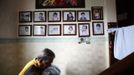 South Korean pastor Lee Jong-rak carries a baby, abandoned a day earlier at a "baby box" at his Joosarang church, to hand it over to ward officials as portraits of other abandoned children raised and adopted by him are seen on a wall of the church in Seoul September 20, 2012. Lee, who runs the "baby box" where mothers can leave unwanted infants, has seen a sharp increase in the number of newborns being left there because, the pastor says, of a new law aimed protecting the rights of children. South Korea is trying to shed a reputation of being a source of babies for adoption by people abroad. It is encouraging domestic adoption and tightening up the process of a child's transfer from birth mother to adoptive parents. Picture taken September 20, 2012. REUTERS/Kim Hong-Ji (SOUTH KOREA - Tags: SOCIETY) Published: Říj. 7, 2012, 6:59 dop.