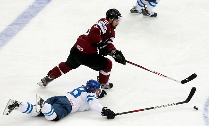 Latvia's Kaspars Daugavins (top) and Latvia's Zemgus Girgensons chase the puck during the second period of their men's ice hockey World Championship group B game at Minsk