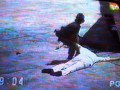 Záběr z nahrávky, která obletěla svět. Příslušník letištní ostrahy odklízí bezvládné Aquinovo tělo z přistávací dráhy. Dnes nese manilské mezinárodní letiště, kde k atentátu došlo, jeho jméno