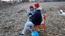 Záběr na sedícího muže s dítětem, kteří uprchli před válkou na Ukrajině. Fotografie byla pořízená nedaleko státní hranice u obce Tiszabecs v Maďarsku.