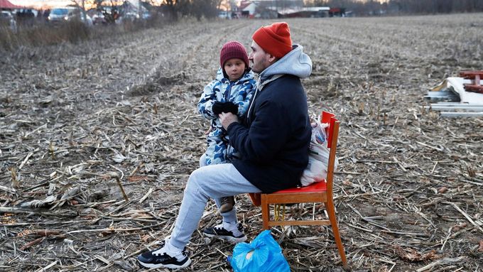 Záběr na sedícího muže s dítětem, kteří uprchli před válkou na Ukrajině. Fotografie byla pořízená nedaleko státní hranice u obce Tiszabecs v Maďarsku.