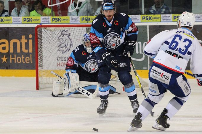 4. semifinále play off extraligy 2018/19, Kometa Brno - Liberec: Taylor Doherty se staví proti střele Ondřeje Němce (v pozadí brankář Roman Will).