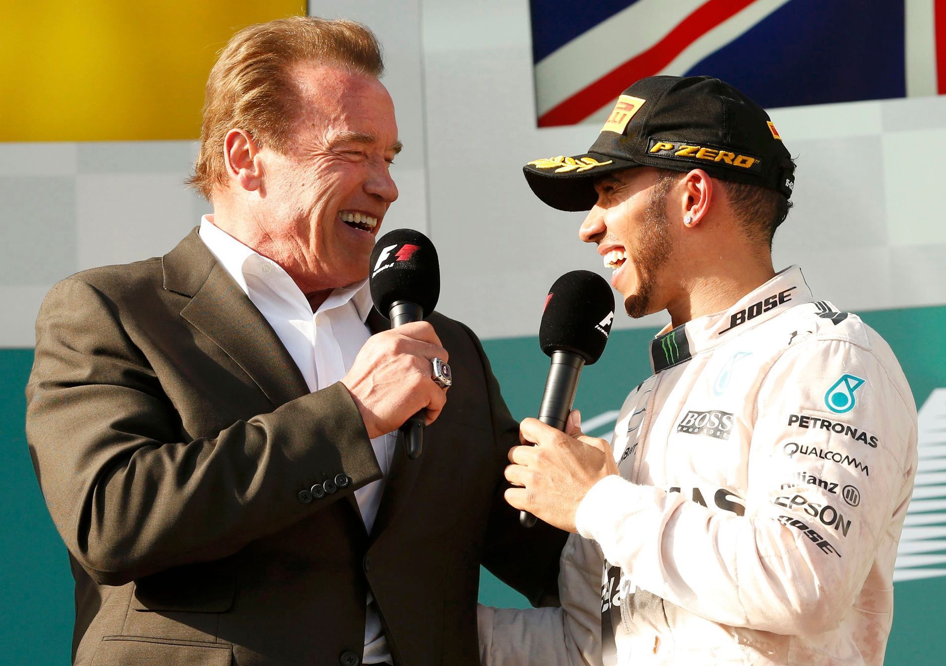 Race winner Mercedes Formula One driver Lewis Hamilton of Britain and actor Arnold Schwarzenegger speak during the podium ceremony of the Australian F1 Grand Prix at the Albert Park circuit in Melbour