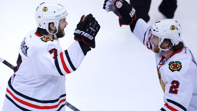 Chicago Blackhawks' Brent Seabrook (L) celebrates his game-winning goal against the Boston Bruins with teammate Duncan Keith during overtime in Game 4 of their NHL Stanle