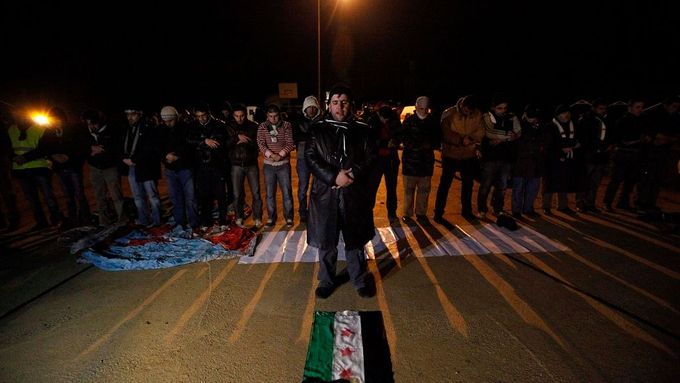 Účastníci konvoje při společné modlitbě na turecké straně hranic.