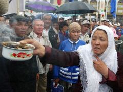 Kyrgyzská žena drží hrnec s hořícími vonnými tyčinkami na znamení dobré vůle, během nedělní demonstrace na hlavním náměstí Ala-Too v Biškeku.