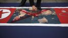 An activist from an anti-North Korea civic group defaces a North Korea flag depicting North's leader Kim Jong-un (R) and his wife Ri Sol-ju (L) during a rally against North Korea's nuclear test near the U.S. embassy in central Seoul February 12, 2013. North Korea conducted its third-ever nuclear test on Tuesday, a move likely to anger its main ally China and increase international action against Pyongyang and its new young leader, Kim Jong-un. U.N. Secretary-General Ban Ki-moon condemned North Korea's test, saying it was a "clear and grave violation" of U.N. Security Council resolutions. REUTERS/Kim Hong-Ji (SOUTH KOREA - Tags: CIVIL UNREST POLITICS) Published: Úno. 12, 2013, 8:01 dop.