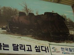 Obraz v hale nádraží ukazuje rozstřílenou lokomotivu, která zůstala na linii rozdělující nepřátelské strany.