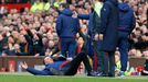 Manchester United manager Louis van Gaal lies on the side of the pitch to demonstrate a foul to the fourth official Mike Dean