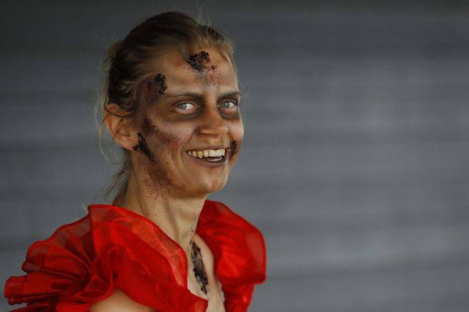 A zombie waits to chase runners at the "Run for Your Lives" 5K obstacle course race in Amesbury, Massachusetts May 5, 2012. Runners face man-made and natural obstacles on the course, while being chased by zombies, who try to take "health" flags off the runners belts. REUTERS/Brian Snyder (UNITED STATES - Tags: SPORT SOCIETY) Published: Kvě. 5, 2012, 8:08 odp.