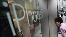 A man peeks inside an Apple Store ahead of sales of Apple Inc's iPhone 5 in Tokyo September 21, 2012. Apple Inc's iPhone 5 hit stores around the globe on Friday, with fans snapping up the device that is expected to fuel a huge holiday quarter for the consumer giant. REUTERS/Yuriko Nakao (JAPAN - Tags: BUSINESS SCIENCE TECHNOLOGY) Published: Zář. 21, 2012, 1:45 dop.